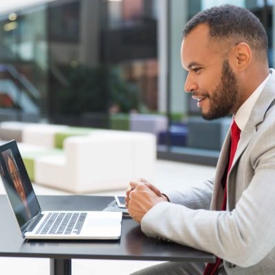 cheerful-businessman-chatting-via-laptop